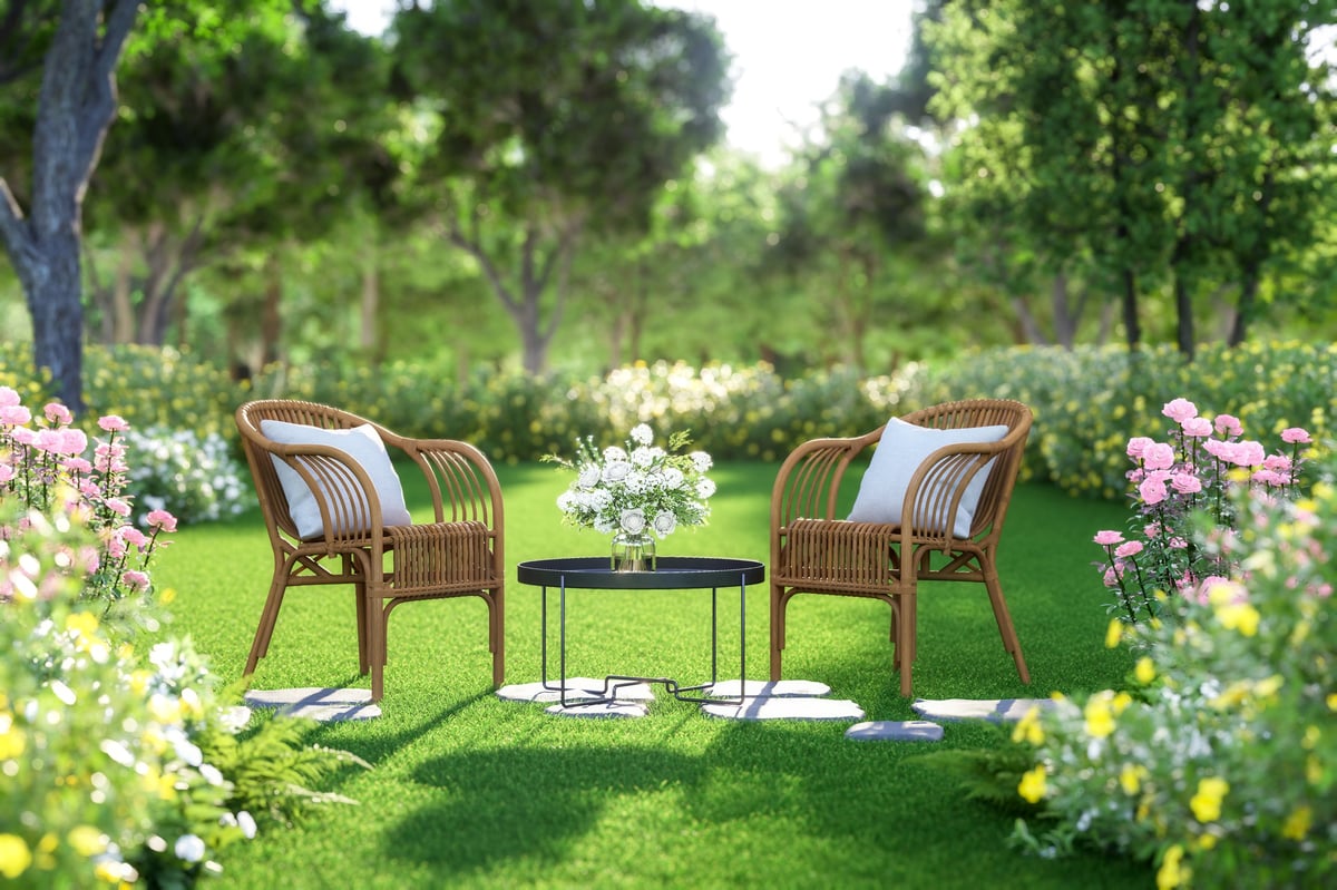 A landscaped garden patio with seating surrounded by lush greenery